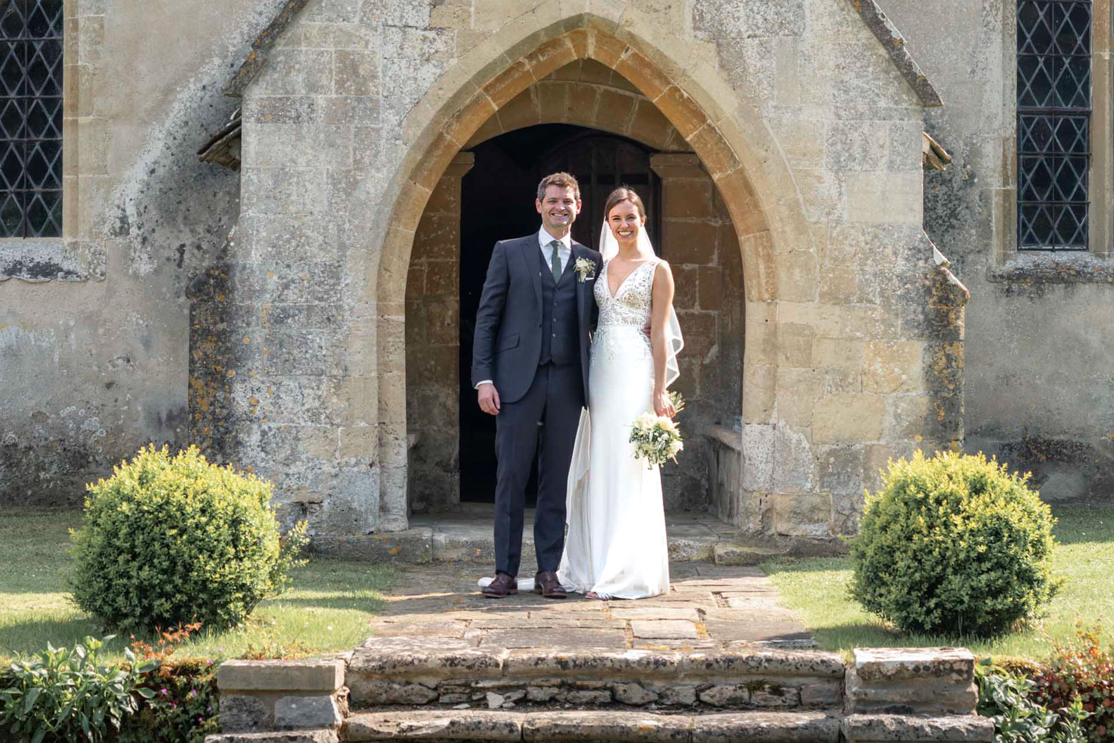 Bride & Groom stand proudly outside the chapel