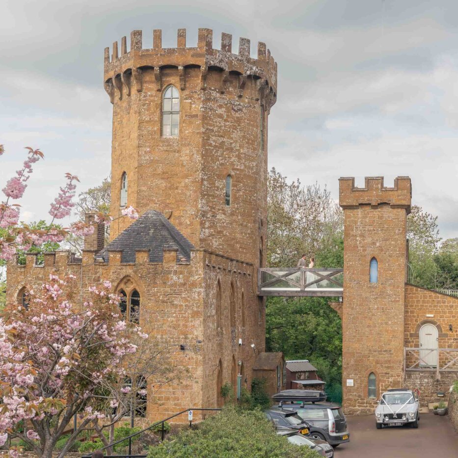 Married couple kissing on the bridge at the Castle at Edge Hill